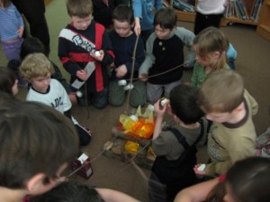 children roasting marshmallows over a fake fire