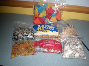 materials used for snowman activity including tissue paper, kernels, pasta, beans, buttons, and seashells