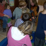 children examining a fiddle