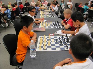 children facing one another in chess games