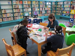 librarian and kids working on crafts at a table