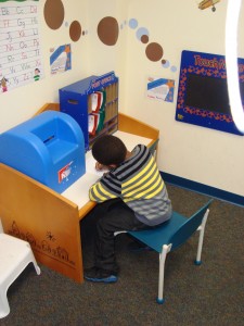 child writing a letter near a mailbox