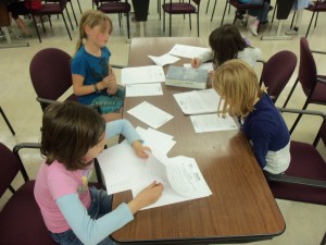 children working on sheets at a table