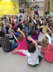 children sitting on the floor waiving their hands