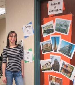 Amy with educational posters on a door for architecture