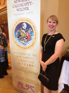 woman posing with banquet banner