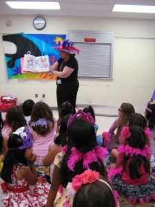 adult reading aloud to children sitting on the floor