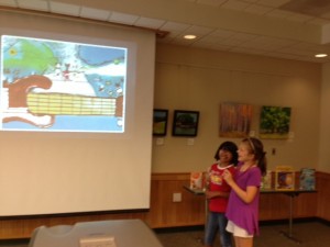 two girls standing by a screen