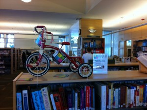 small bike on display atop a book shelf