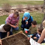 children planting seeds with adults