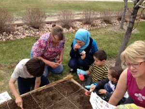 children planting seeds with adults