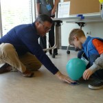 adult and child engaging in a science experiment with a balloon
