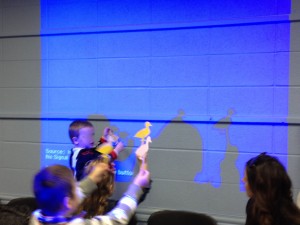 children using Popsicle stick puppets to make shadow puppets