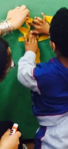 hands pasting paper onto a mural
