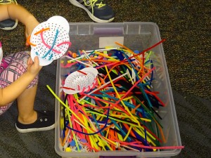pipe cleaner through colander in a plastic tub