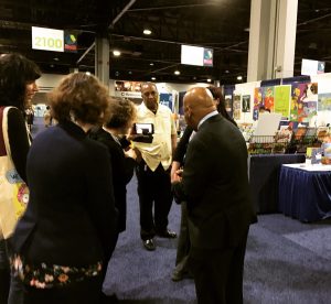 Photo of John Lewis and others in exhibit hall at ALA Midwinter Meeting