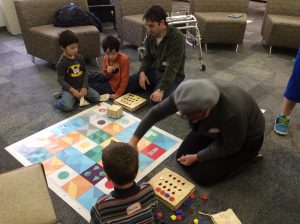 Children & adults playing on the floor at the library