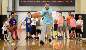 Coach Terrance Miles working with a group of kids about basketball
