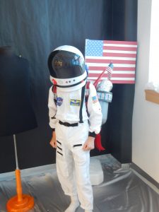 Astronaut in a space suit in front of American flag
