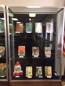 Display case of book covers focusing on books with "spaced out" theme from the de Grummond collection