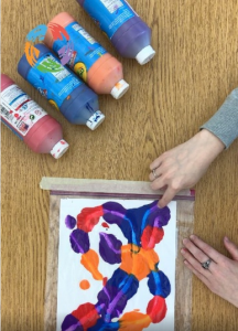 Two hands squishing paint in a bag to create mess-free art