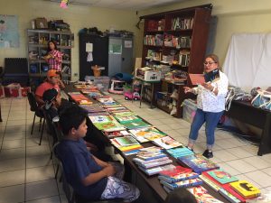 REFORMA's Children in Crisis project image of woman reading to children.