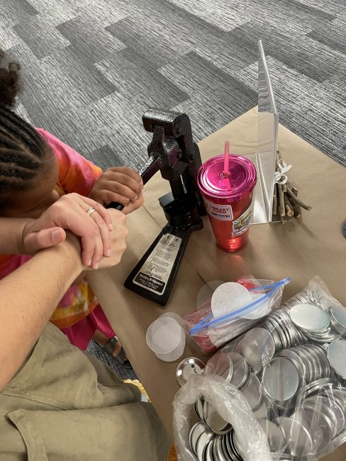 A 5 year old girl making a button at the library's Hobbit Day Party