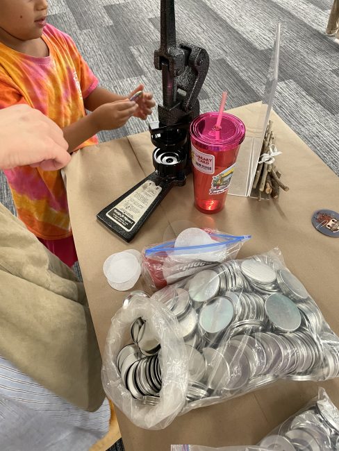 A 5 year old girl making a button at the library's Hobbit Day Party