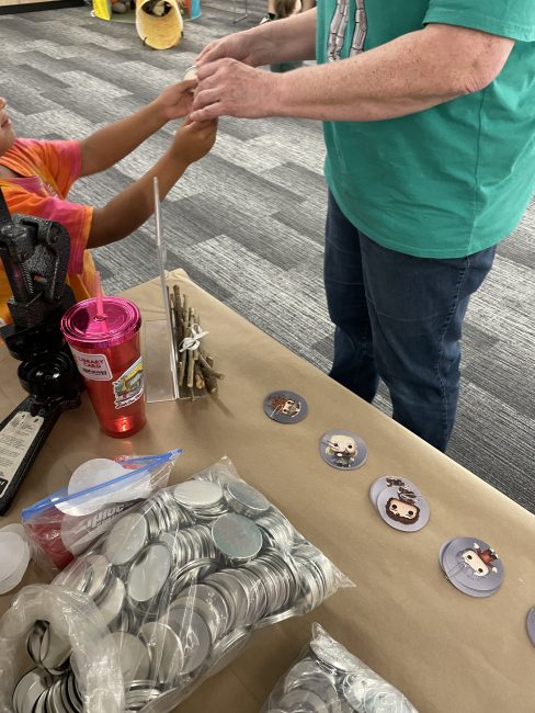 A 5 year old girl making a button at the library's Hobbit Day Party
