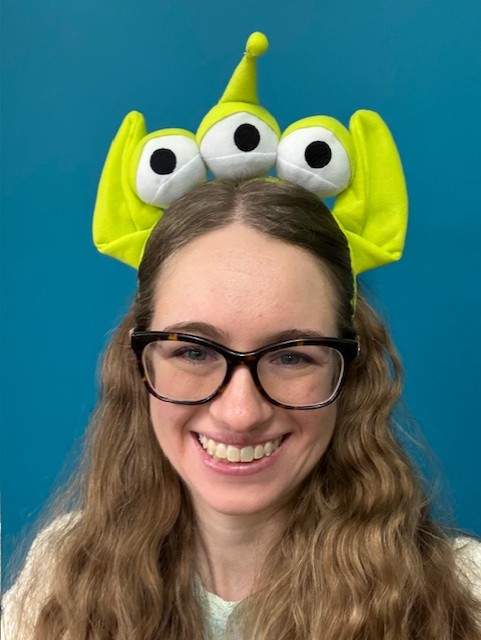 A photograph of Ann Baillie wearing an alien headband for a mystery program. Photo Credit Ann Baillie