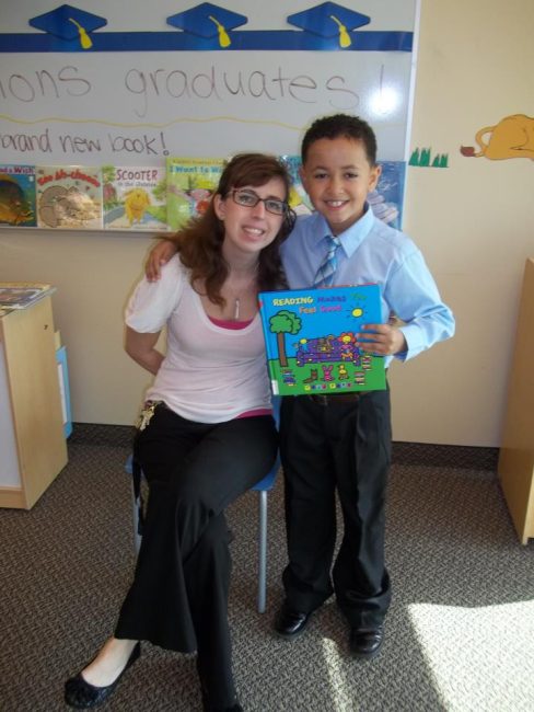 A librarian and a young child at story time, with the child holding a book.
