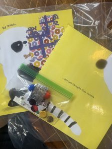 Two yellow book pages removed from their book with a small bag of craft supplies on top