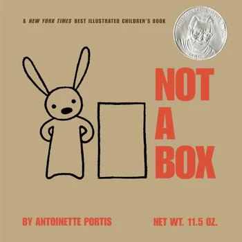 A book cover appears as a cardboard box. Black lettering at the top reads A New York Times Best Illustrated Children's Book. Underneath, a black line drawing shows a rabbit standing next to a black rectangle. To the right, red text reads Not a Box. Underneath, red text reads by Antoinette Portis Net Wt. 11.5 oz. In the top right corner, a silver Theodore Seuss Geisel award seal is visible.