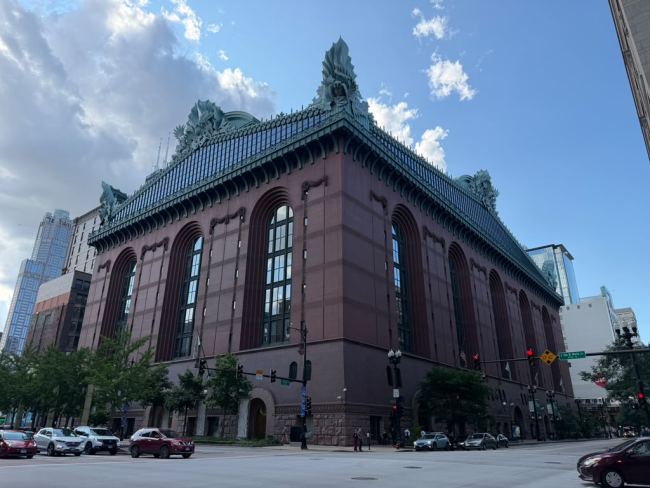 Chicago Public Library building from the outside -- big, brown walls, with tall windows, and green statue decorations on top